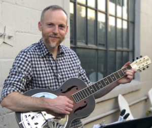 Photo of a man and a guitar